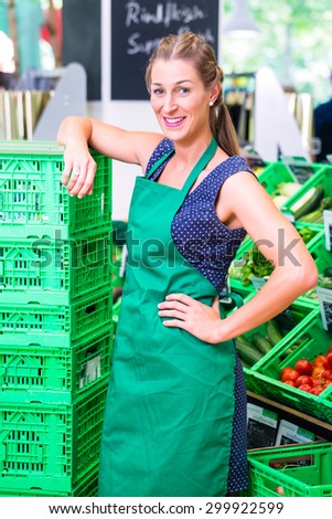 Female Supermarket clerk filling up storage racks in vegetable department