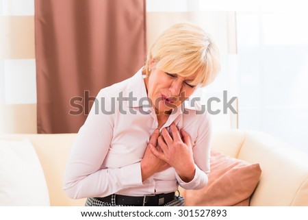 Old woman holding breast because of heart infarction