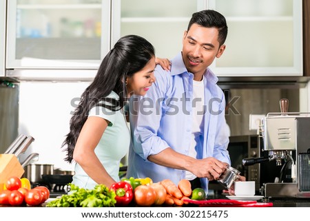 Asian couple, man and woman, cooking food together in kitchen and making coffee