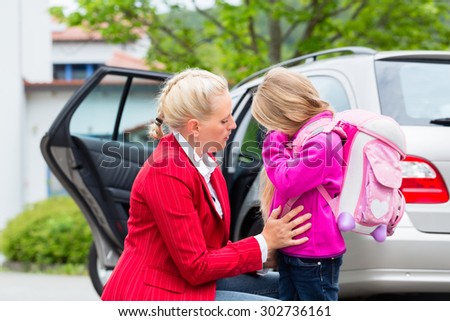 Mother consoling daughter on first day at school, the kid being a bit afraid of what may lay ahead