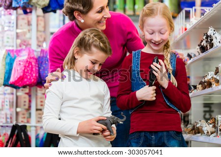 Family buying toys in toy store in toy store standing on a shelf choosing figures