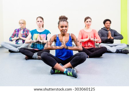 Group for friends in yoga class meditating