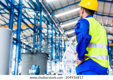 Industrial worker in Asian factory with tools going to machine maintenance