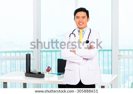 Asian doctor standing proud in his office or medical practice