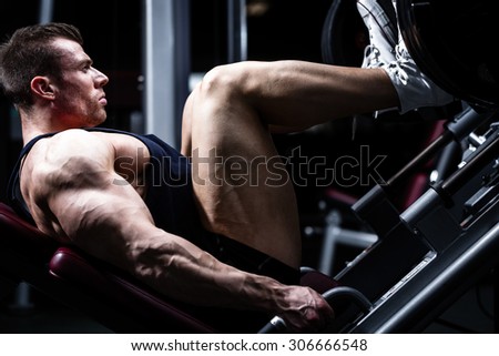 Man in gym training at leg press to define his upper leg muscles