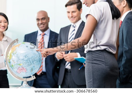Business people in Strategy meeting discussing new markets looking at a globe