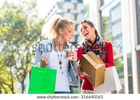 Friends, two women, shopping with bags in city