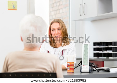 Young female doctor sitting with pensioner in surgery consultation hour at desk