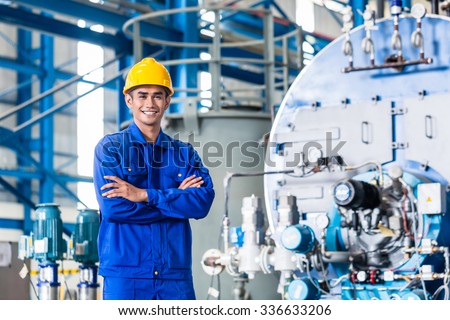 Proud Asian worker standing in production factory