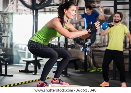 Group of men and woman in functional training gym doing fitness exercise