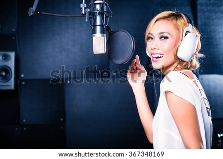 Asian professional musician recording new song or album CD in studio