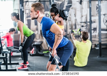 People exercising in functional fitness gym, group of women and men