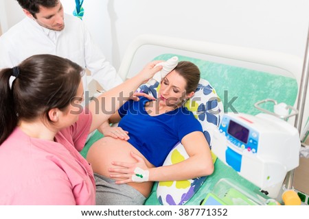 Pregnant woman in labor room with doctor and nurse