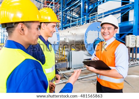 Asian factory worker and engineer as team inspecting a machine delivery
