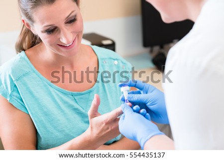 Diabetes test on blood sample of pregnant woman in examination at gynecologist office