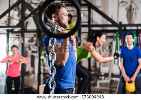 Man lifting dumbbell and chain in functional training gym session