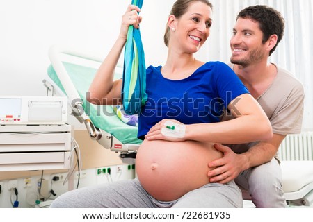 Pregnant woman and man in delivery room of hospital before birth