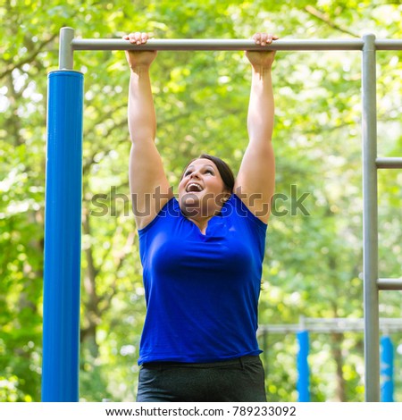 Fit woman preparing for the pull-ups on the horizontal bar Stock