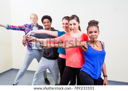 Group of happy young people having dance lessons