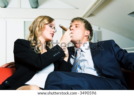 Secretary helps her boss smoke a cigar