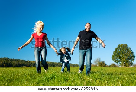 Young family having fun in the sun running