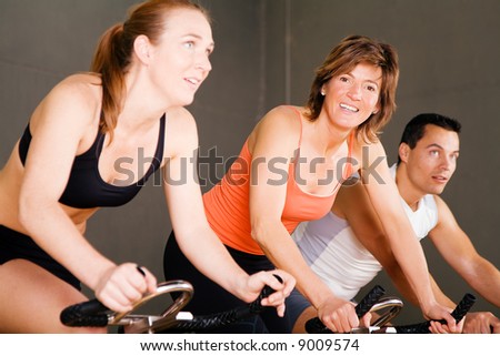 Three people in the gym, focus on the smiling woman in the middle