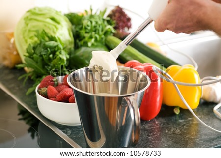 Cook preparing cream using a kitchen mixer