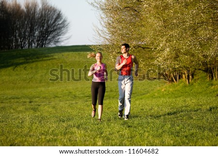 Athletic young couple jogging in a evening mood at a perfect spring day