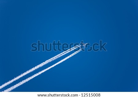 Jet with vapor trail in a clear blue sky