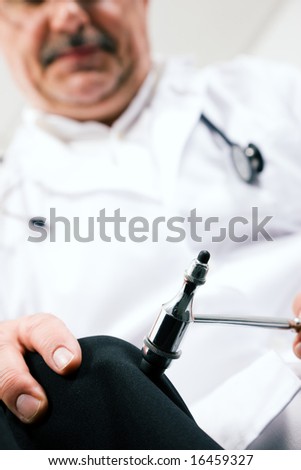 Medical doctor testing reflexes on a female patient using a little hammer
