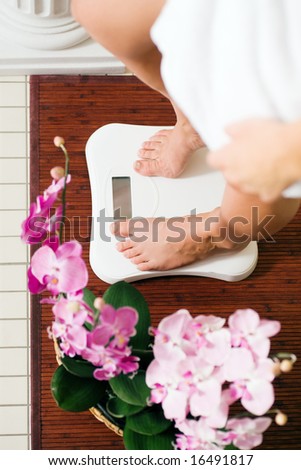 Woman (only feet to be seen) standing on a scale in a spa setting