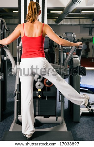 Young woman exercising at a machine that strengthens the lower back (for a sexy bottom)