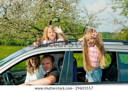 Family travelling by car, kids waving their hands