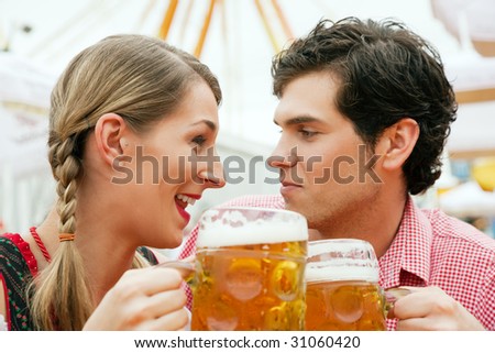 Couple in traditional German costume in a beer tent having a drink