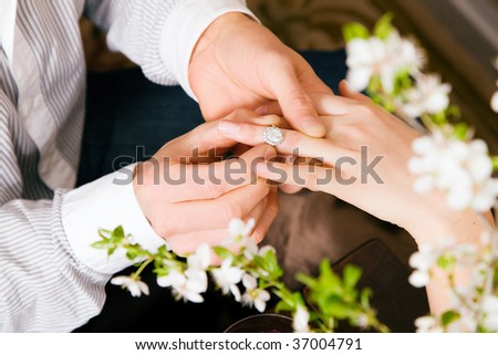 Couple - he is proposing marriage by giving the ring