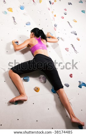 Woman exercising at a climbing wall in a gym