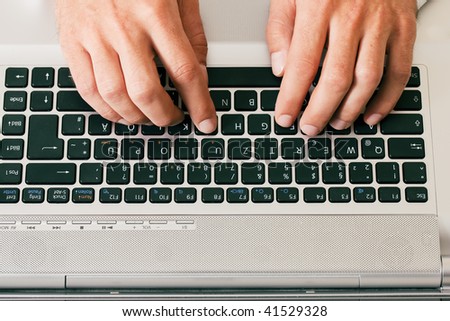 Man (only hand to be seen) using a computer keyboard typing
