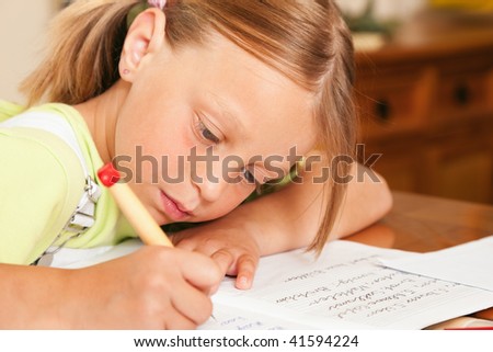 Girl preparing her homework for school writing in her exercise book