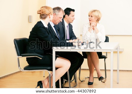 Small business team having a meeting in the office sitting on a table discussion various topics