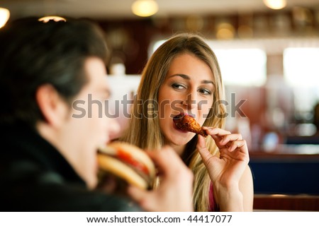 http://image.shutterstock.com/display_pic_with_logo/84610/84610,1263391913,4/stock-photo-couple-in-a-restaurant-or-diner-eating-a-hamburger-and-chicken-wings-flirting-the-while-shot-with-44417077.jpg