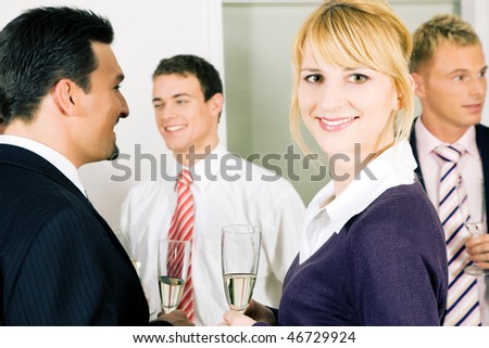 People in business outfit celebrating something in the office or at a gathering, maybe they toast on a successful deal or something the like