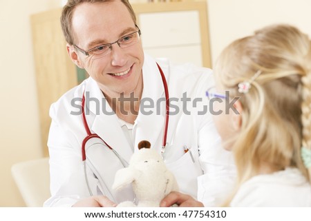 Doctor - Pediatrician - with a child patient in his practice, she is ging him her soft toy as to thank him