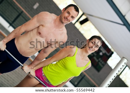 Sportive couple does some training on the high bar together