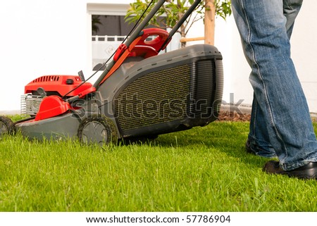 Man mowing lawn in his garden or front yard in summer