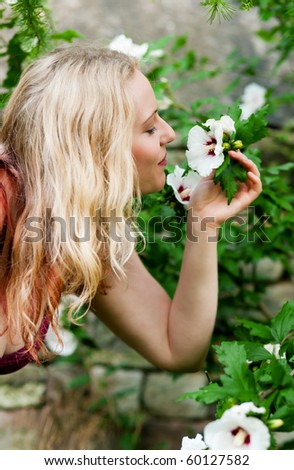 Very beautiful Woman in her garden taking a sniff at some flowers