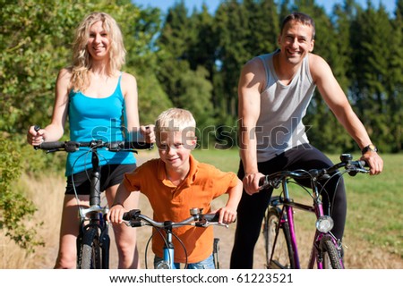 Family with child on their bikes on a summer day in sport outfit, they are exercising