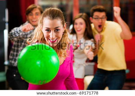 Three Friends Laughing In Bowling Alley Of Four Friends In A Bowling Alley Three