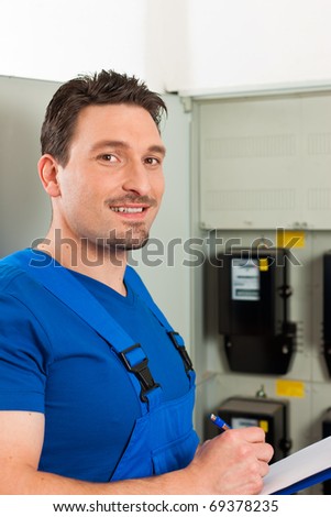 Technician reading the electricity meter to check consumption