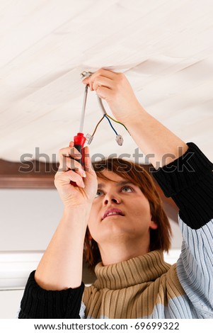 Female worker doing work on electrical installation