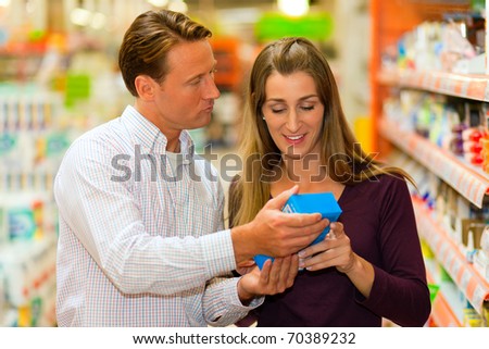 Couple in a supermarket shopping groceries and other stuff, they are looking for what they need